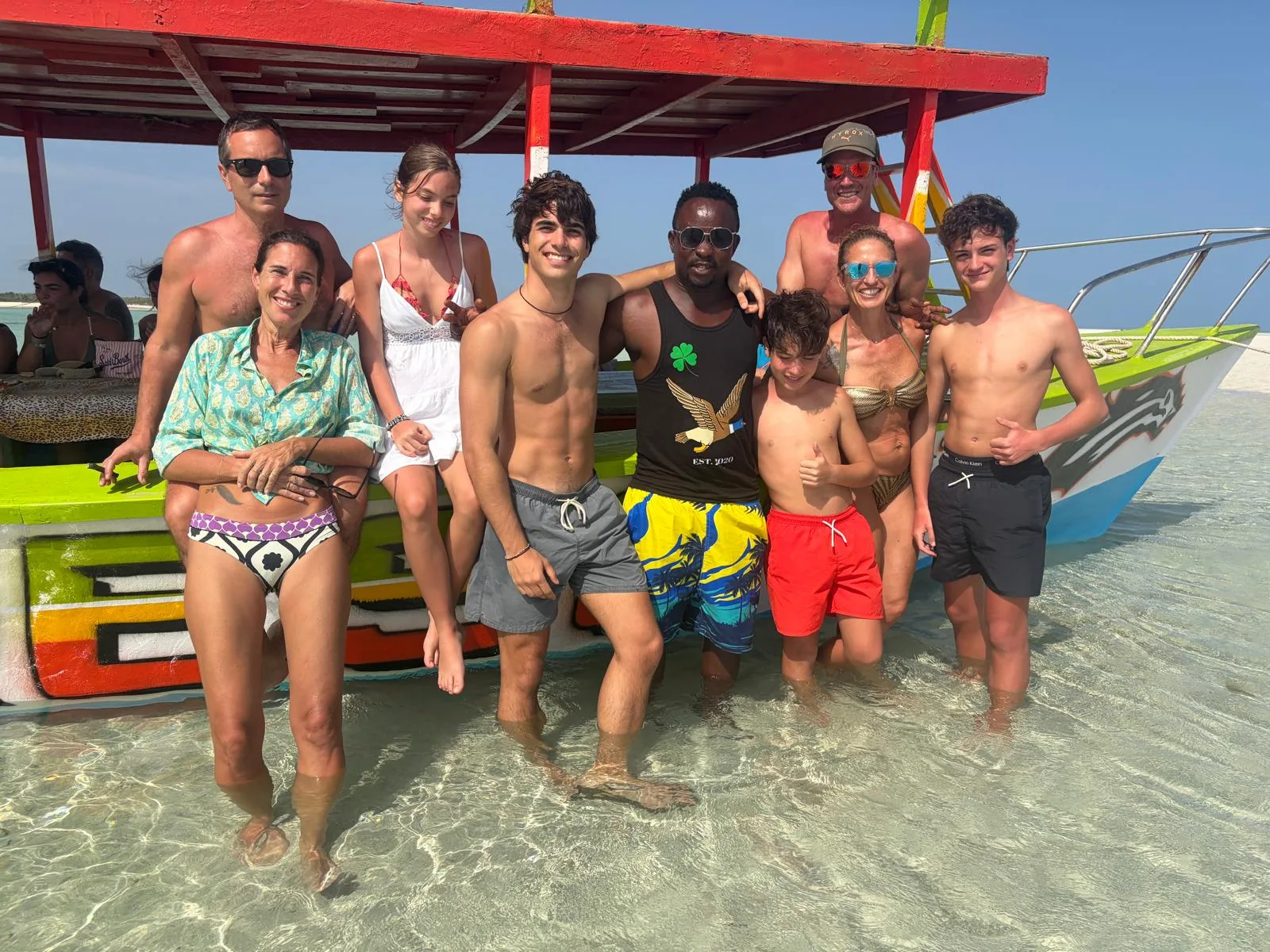 Famiglia e accompagnatore sorridono davanti alla barca del Safari Blue