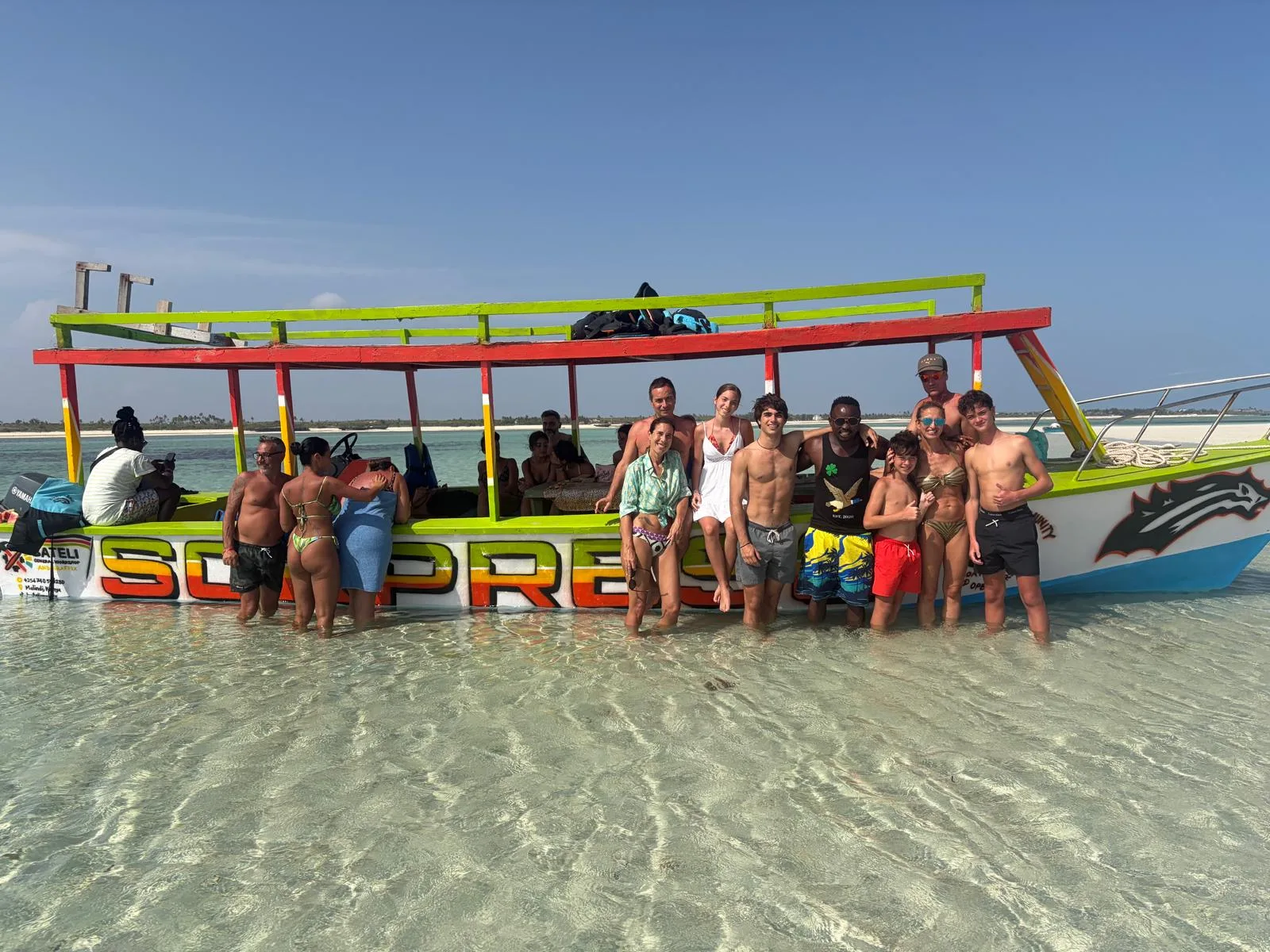 Gruppo di viaggiatori insieme alla guida davanti alla barca del Safari Blue